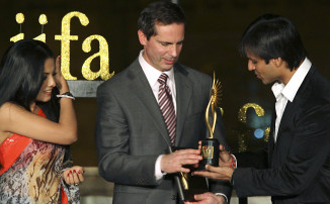 Bollywood actor Vivek Oberoi, right, presents the International Indian Film Academy (IIFA) trophy to Dalton McGuinty, Premier of Ontario, as fellow Bollywood actor Celina Jaitley looks on during a function in Mumbai, India, Wednesday, Dec. 9, 2009.