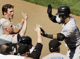 Bautista  is greeted by teammates after his April 11 two-run homer in Baltimore. JOE GIZA/REUTERS. 