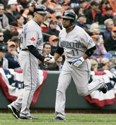 Jays’ third base coach Brian Butterfield (l) greets base runner Alex Gonzalez as he rounds third base after hitting homer in Baltimore, April 9. 