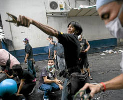 An anti-government Red Shirt protester launches a slingshot loaded with a large firecracker toward Thai soldiers as clashes continued in Bangkok on Monday, May 17. Getty Images.