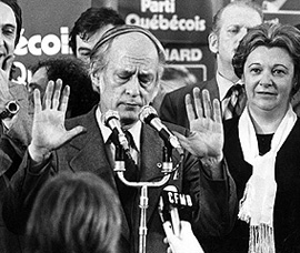 An already somewhat harassed new QuÃ©bec Premier RenÃ© LÃ©vesque tries to calm supporters at Parti QuÃ©bÃ©cois rally in MontrÃ©al, following his party's first QuÃ©bec election victory, November 15, 1976.