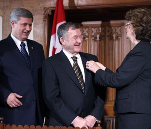 Senator Marjory LeBreton (r), Leader of the Government in the Senate, places the Senate pin on new Conservative Senator Bert Brown (c) as Prime Minister Stephen Harper looks on, October 16, 2007.