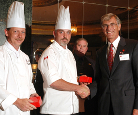 Senator James Cowan (right) presents gifts to Chef Allan Williams (centre) and Chef Blair Zinck (left) of the Culinary Institute of Canada, during the Taste of Atlantic Canada reception. Chicago, October 2005. 