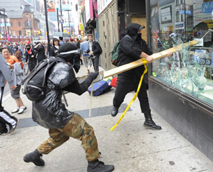 LUCAS OLENIUK (photo): An anarchist group travelling north on Yonge Street smashes windows.