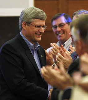 Canada's Prime Minister Stephen Harper greets members of the Conservative caucus during a meeting on Parliament Hill in Ottawa August 5, 2010. 